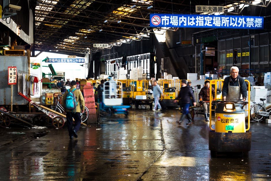 Lively scene at a Tokyo wholesale market featuring carts and transport vehicles.